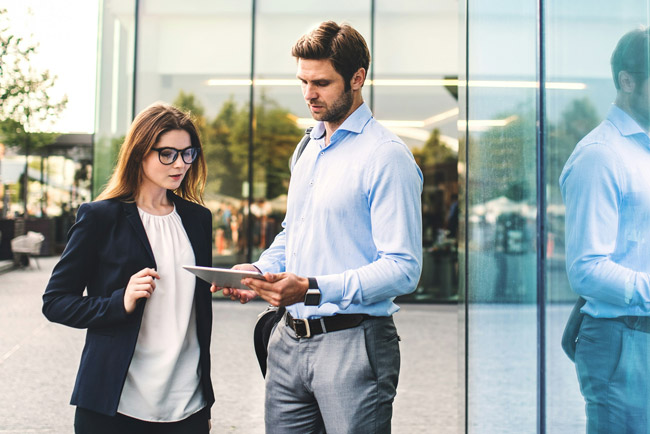 Imagebild Mann und Frau besprechen sich vor dem Office Gebäude